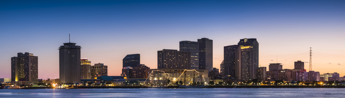 New Orleans skyline looking across the Mississippi River at sunset.